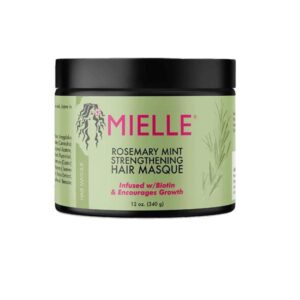 Mielle Rosemary Mint Strengthening Hair Masque in a jar with mint leaves.